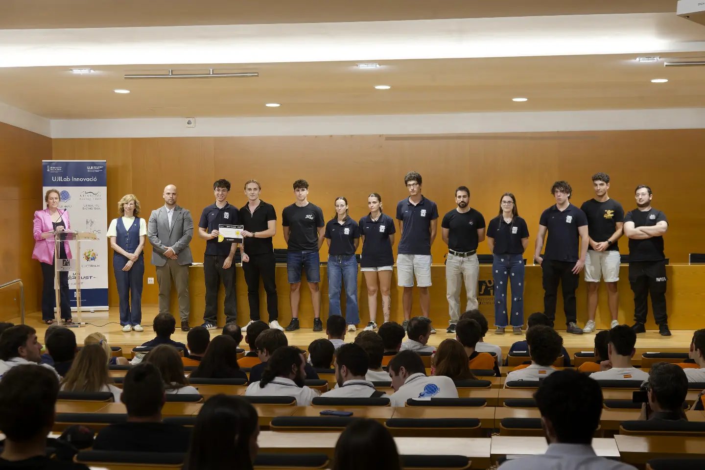 Equipo de UJI Robotics Team recogiendo su reconocimiento sobre el escenario en la presentación de equipos de UJILab Innovació