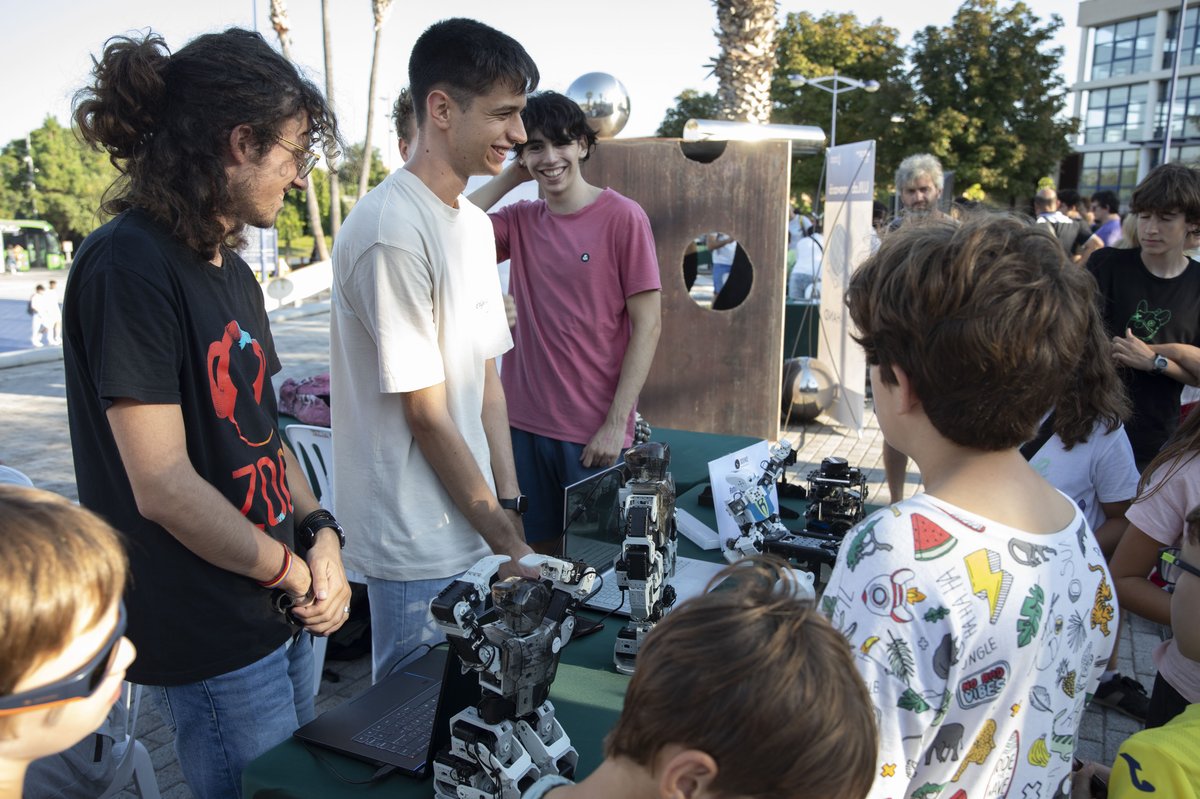 Miembros de UJI Robotics Team mostrando uno de sus robots en una feria de divulgación científica